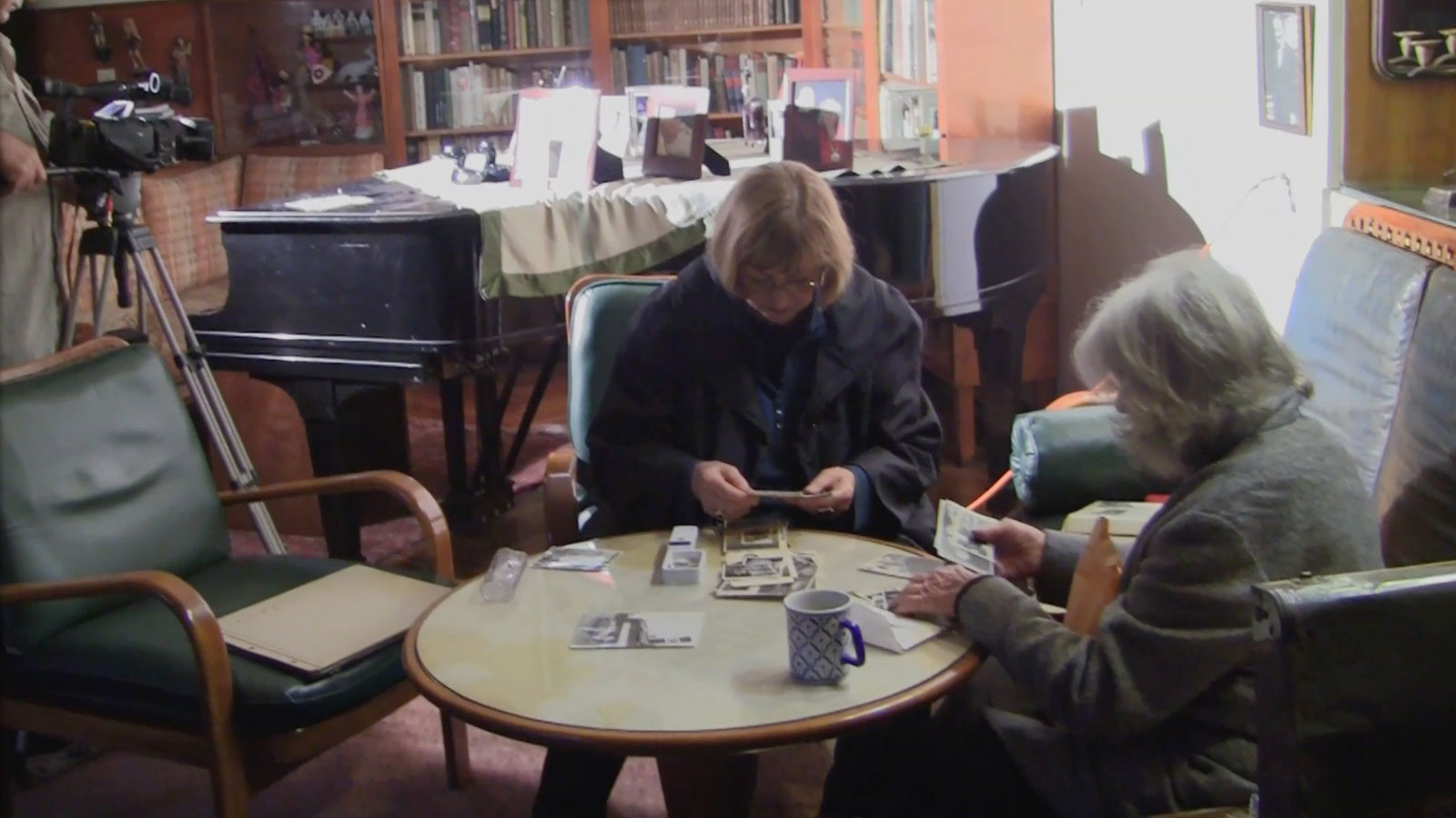 Shooting in Ecuador. The film's director, Eva Zelig, selects photos in the Quito home of a Jewish refugee from Prague.